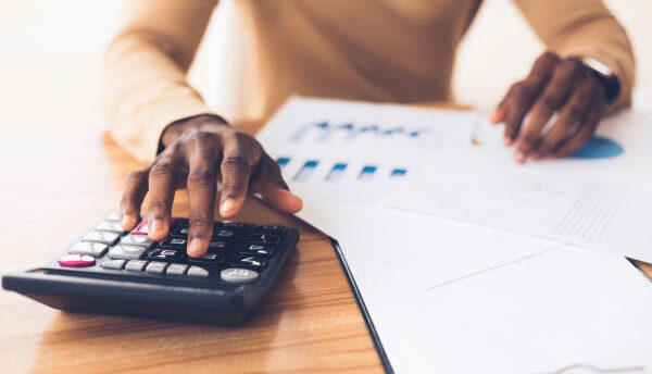 istockphoto-1191634510-612x612 Budget Planning. Unrecognizable black businessman using calculator, tracking income and expenses. Panorama, copy space
